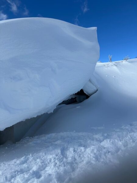 飯縄山の避難小屋の中で温かい飲み物で休む