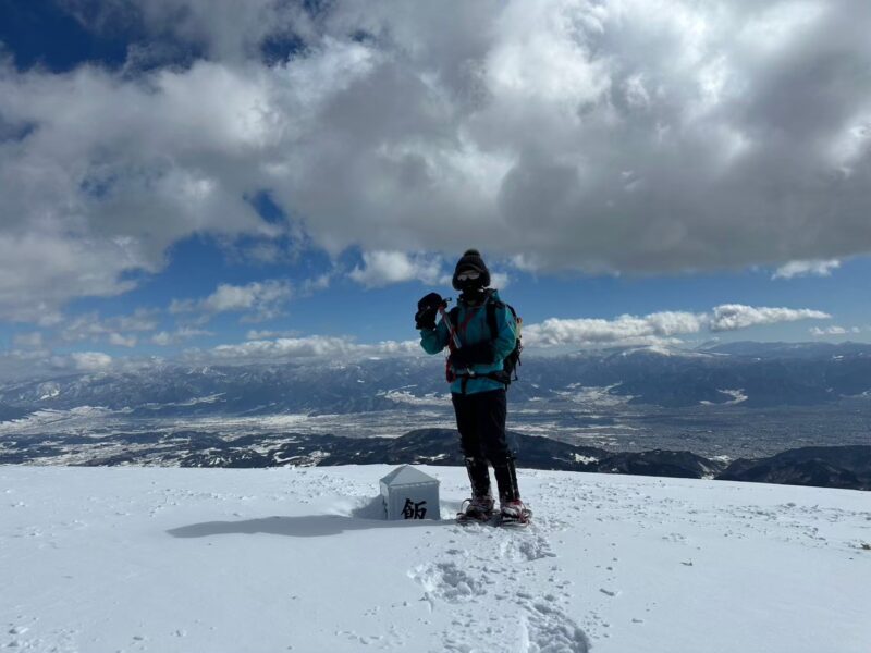 快晴の山頂でピッケルを掲げるもおすけ
