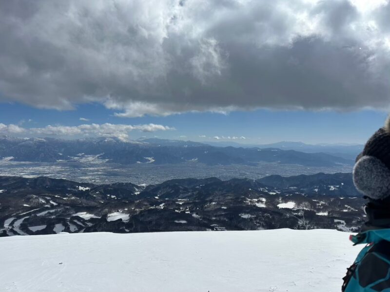 飯縄山の雪化粧した森からの透き通る冬の空と街