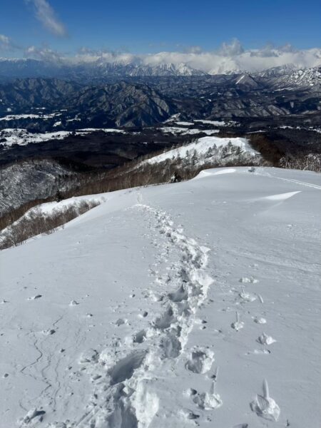 白い尾根の向こうに見える山並み