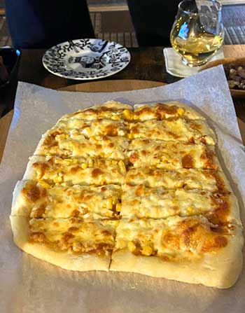チーズたっぷりのコーンをのせた手作りピザ