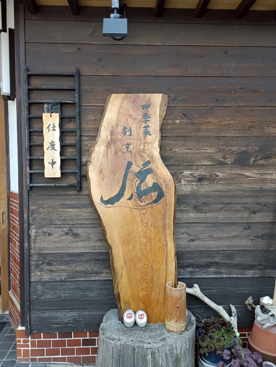 四季菜割烹伝の一枚板の看板と仕度中の札、佐渡の食事処の入口