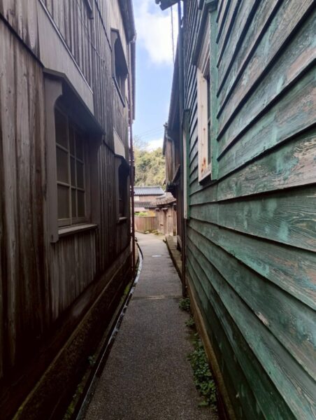 黒く焼けた板壁の家が並ぶ宿根木の狭い路地、北前船で栄えた集落