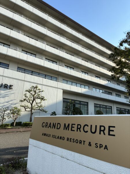 グランメルキュール淡路アイランドリゾート&スパの外観と入口の看板、秋の青空